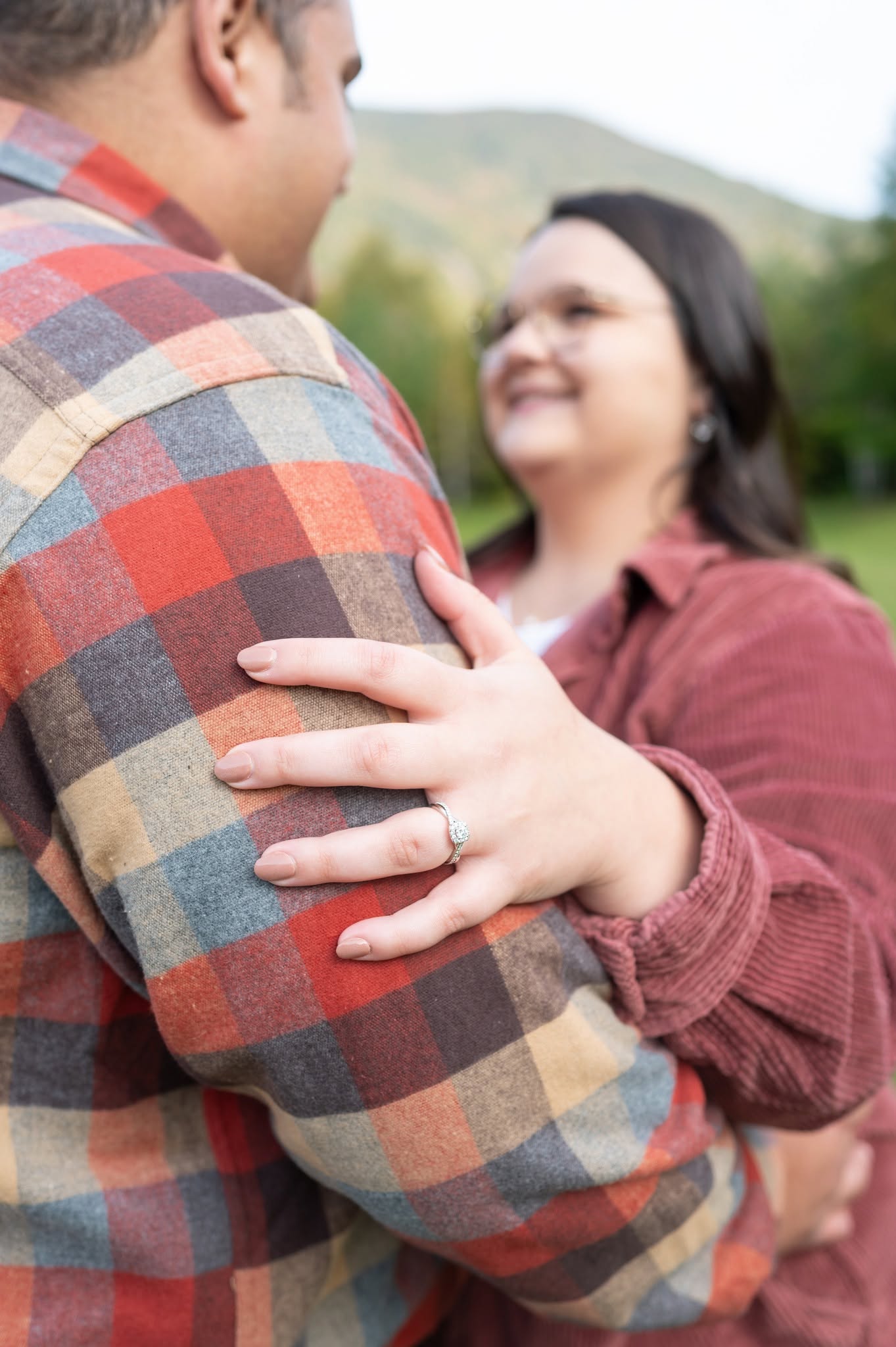 A couple in autumn flannel sharing a quiet moment during an engagement session.
